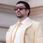Bad Bunny in a cream suit and sunglasses